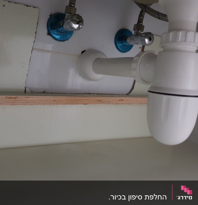 צנרת פלסטיק מתחת לכיור עם ברזים כחולים